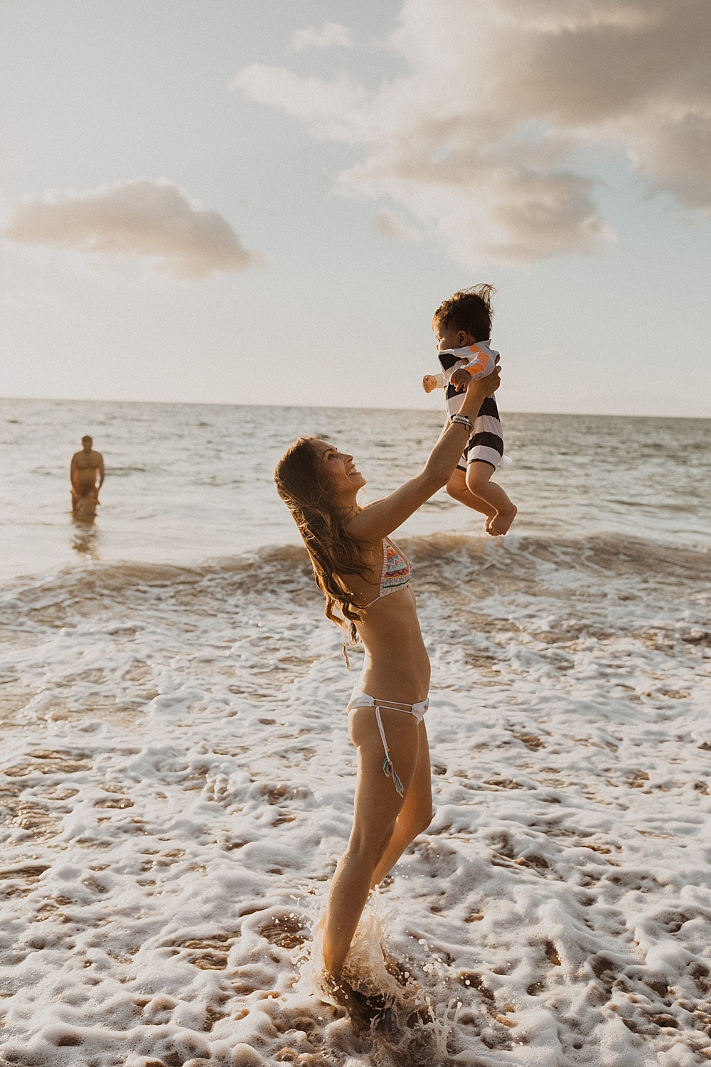 mom throwing son in air during her family photo session on Maui 